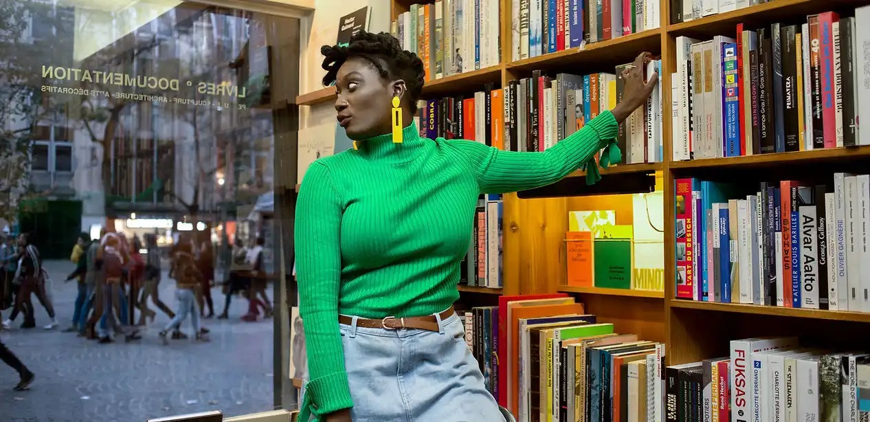 Woman reading near a bookshelf representing LiberoReads publishing and book community